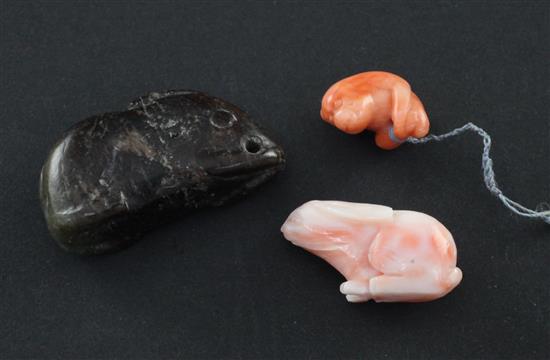 Two Chinese coral carvings, of a seated monkey and a rabbit and a black and green jade carving of a rabbit, all 19th century,